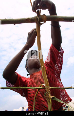 Cyuve, camp de réfugiés du Rwanda, de l'éruption du volcan Nyriragongo le 18 Jan 2002 dans les environs de Goma en RDC. Samuel, 15 ans, est de faire un abri pour lui-même dans le camp. Il a été la vente de cigarettes et de biscuits dans la rue quand la lave a frappé la ville. Sa maison a été détruite et sa famille est dispersée, mais il veut revenir à Goma pour les trouver. Banque D'Images