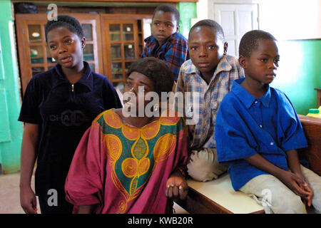 Camp d'Ibanda, à Bukavu, à l'emplacement d'un ancien centre de formation du corps de la paix, pour les personnes déplacées de Goma par la coulée de lave après une éruption volcanique, Jan 2002 groupe familial dans le bâtiment principal du camp. Banque D'Images