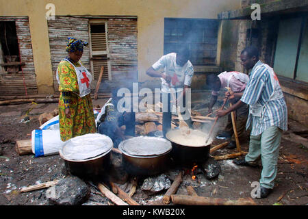 Camp d'Ibanda, à Bukavu, à l'emplacement d'un ancien centre de formation du corps de la paix, pour les personnes déplacées de Goma par la coulée de lave après une éruption volcanique, Jan 2002 travailleurs Camp la cuisson des aliments en grandes quantités Banque D'Images