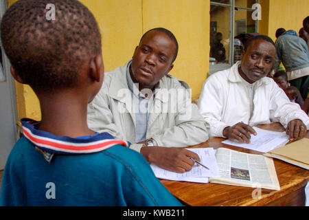 Camp d'Ibanda, à Bukavu, à l'emplacement d'un ancien centre de formation du corps de la paix, pour les personnes déplacées de Goma par la coulée de lave après une éruption volcanique, Jan 2002 personnes exécutant l'entretien du camp une nouvelle arrivée. Banque D'Images