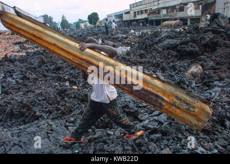 Quand le volcan Nyriragongo le 18/01/2002 la lave coulait dans Goma en RDC, détruisant un tiers de la ville. de la ville. Des gens comme ce jeune garçon à pied à travers le circuit de refroidissement de la lave pour fouiller ce qu'ils peuvent de la des immeubles en ruines. Banque D'Images