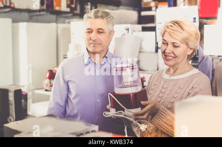 L'homme et la femme 47-57 ans sont l'achat en boutique d'électroménager et de l'extracteur de jus broyeur pour elle-même à la maison. Banque D'Images