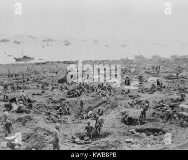 Les soldats dans des trous sur le bord sud-est de l'Aérodrome de Motoyama # 1, Iwo Jima. Les engins de débarquement sont échoué sur la droite. 23 février, 1945. La Seconde Guerre mondiale 2. (BSLOC   2014 10 114) Banque D'Images