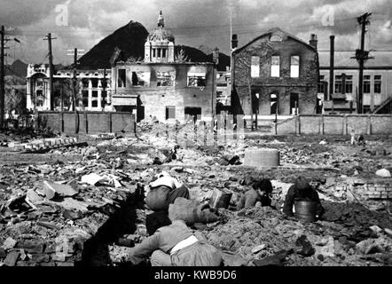 Les femmes et les enfants coréens recherchez les décombres de Séoul pour tout ce qui peut être utilisé ou utilisé comme combustible. Le 1 novembre 1950. La 2e bataille de Séoul en septembre 1950, serait suivie par trois autres en janvier 1951, mars 1951 et avril 1951. Guerre de Corée, 1950-1953. (BSLOC   2014 11 60) Banque D'Images