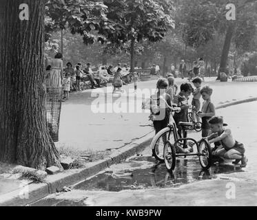 Les enfants qui jouent près d'une flaque de tricycles à Washington Square Park. New York City le 3 août 1948. (BSLOC   2014 13 167) Banque D'Images