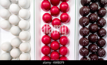 Pralines au chocolat en trois couleurs photographié par le haut. Banque D'Images