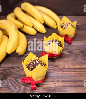 Muffins aux bananes et bananes fraîches sur un fond de bois brun, vue du dessus Banque D'Images