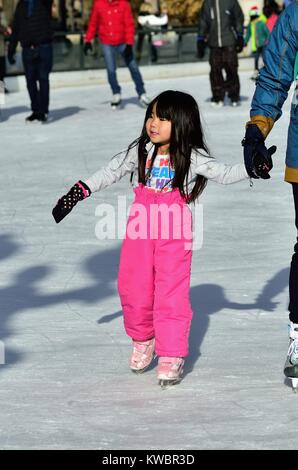 Une jeune fille parmi les patineurs profiter de la patinoire à la Chicago Millennium Park. La patinoire est ouverte tout au long de la saison d'hiver. Chicago, Illinois, USA. Banque D'Images