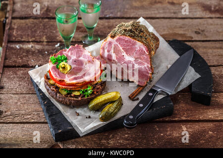 Le seigle délicieux sandwich avec jambon fumé, tomate, confiture d'oignons, de cornichons et de vodka. Banque D'Images