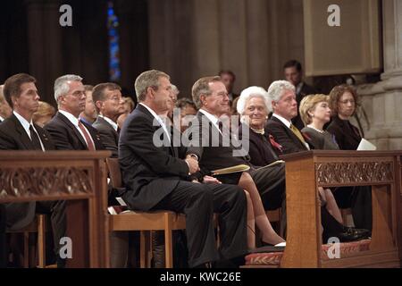 Le Président George Bush saisit la main de son père, l'ancien président George H. W. Ils étaient présents à la Journée nationale de prière et de service commémoratif pour les victimes d'attaques terroristes du 11 septembre. Aussi à l'avant gauche, pew sont de Bush 41, Mme Barbara Bush, l'ancien Président Bill Clinton, la Sénatrice Hillary Rodham Clinton, et Chelsea Clinton. 14 sept 2001. (BSLOC 2015 2 150) Banque D'Images