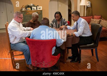 Le président Barack Obama prie avec la famille de l'école enseignant Tiffany Santana à Falls Church, en Virginie le 6 décembre 2012. Le président Obama a visité comme une des 114 millions de familles américaines qui ont fait face à des augmentations d'impôt si le Congrès n'a pas réussi à étendre la réduction d'impôt de la classe moyenne. (BSLOC   2015 13 158) Banque D'Images