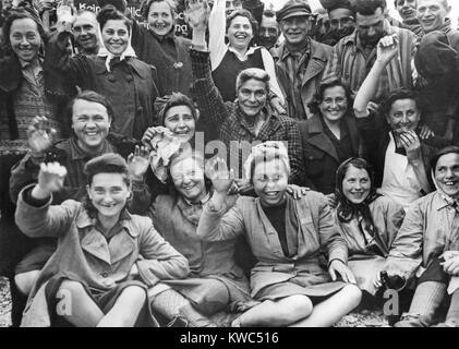 Les prisonnières libérées au camp de concentration de Dachau vague et bravo pour un portrait de groupe. Photo a été prise par le photographe américain Signal Corps, ca. 29 avril 1945, la Première Guerre mondiale (BSLOC 2  2015 13 22) Banque D'Images