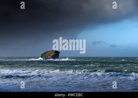 Des nuages de pluie rassemblement autour d'un Gull Rock à Portreath à Cornwall. Banque D'Images