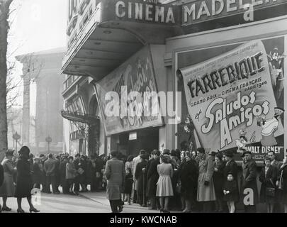 Parisiennes devant un cinéma montrant le film de Disney, "aludos Amigos' en avril 1947. Au Cinéma Madeleine, Boulevard des Capucines, Paris. - BSLOC  2014 (17 126) Banque D'Images