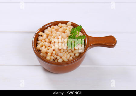 Casserole de haricots blancs en conserve sur fond de bois blanc Banque D'Images