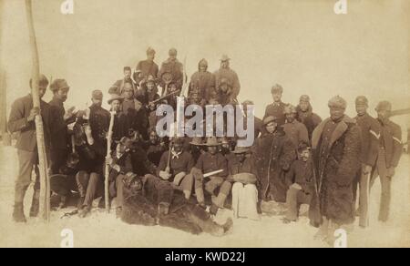 Des soldats Buffalo de la 25e Infanterie, plusieurs portant des peaux de bison, Ft. Keogh, Montana, 1890. À gauche, deux hommes pour atteindre une bouteille d'être adopté alors qu'ils ont posé pour ce portrait de groupe détendue (BSLOC   2017 20 104) Banque D'Images