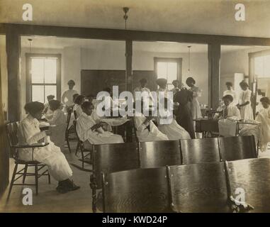 Les femmes afro-américaines à la main et de couture avec machine à coudre dans classe, c. 1911-18. Nannie Helen Burroughs a fondé l'École nationale de formation pour les femmes et les filles, à Washington, D.C. , que pour former les femmes noires pour les travaux domestiques (BSLOC   2017 20 142) Banque D'Images