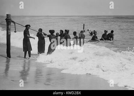 Les Africains Américains profitant de la plage à Asbury Park, New Jersey, en juillet 1908. Les femmes sont habillées de robes de baignade et bas pendant qu'ils jouent dans les vagues (BSLOC   2017 20 122) Banque D'Images