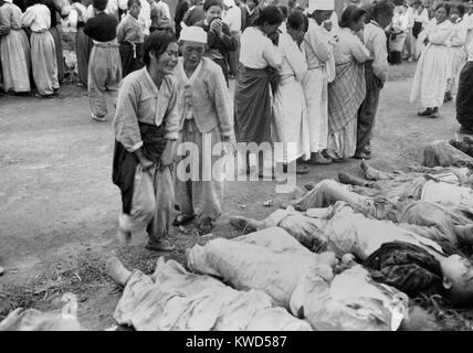 Les coréens de Hamhung identifier des corps des prisonniers politiques tués par l'armée nord-coréenne. Quelque 300 ont été internés dans des grottes qui ont ensuite été scellés, de sorte qu'ils sont morts d'asphyxie. 19 octobre 1950. Guerre de Corée, 1950-1953. (BSLOC   2014 11 239) Banque D'Images