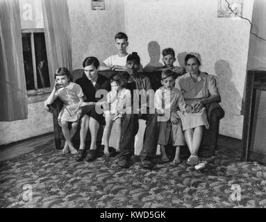 Mineur de charbon, Blaine Sergent, encore couvert de poussière froide du travail, avec sa famille. La jeune femme dans la robe noire est aveugle. Plus les enfants sont jeunes shoeless. Harlan County, Kentucky. Le 15 septembre 1946. Par Russell Lee. (BSLOC   2014 13 158) Banque D'Images