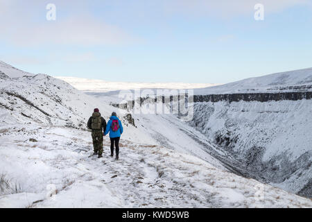 Les marcheurs en direction de coupe élevée pseudo sur le Pennine Way en hiver, Cumbria, Royaume-Uni Banque D'Images