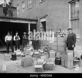 Les agents d'interdiction stand avec des boîtes et des bouteilles de vin et spiritueux après un raid dans la région de Washington D.C.. 14 octobre, 1922. Remarque l'appareil photo homme en haut à gauche (BSLOC 2016 8 69) Banque D'Images