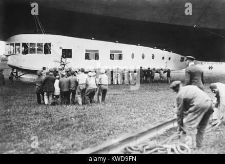 Cabine de l 'USS Los Angeles' au cours de sa cérémonie de mise en service, le 25 novembre, 1924. Les passagers VIP sont à l'intérieur de la "gondola" comme le personnel au sol s'occupe des cordes. Auparavant la désignation ZR-3, le dirigeable airship a été construit en 1923-1924 par la société zeppelin allemand comme une guerre mondiale 1 réparation aux États-Unis (BSLOC   2016 10 171) Banque D'Images