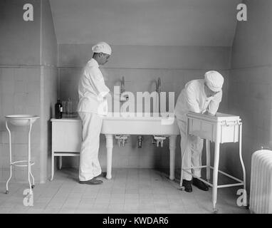 Chirurgien et l'anesthésiste se laver soigneusement les mains et avant-bras dans des puits. Avant les antibiotiques d'une infection postopératoire a été une préoccupation grave. 1922 dans un hôpital de Washington, D.C. (BSLOC   2016 10 31) Banque D'Images