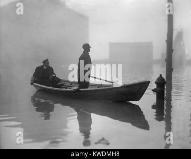 Un Afro-américain constitue un bateau dans Georgetown, au cours d'une inondation de la rivière Potomac 1910-09. Son passager assis porte un uniforme (BSLOC   2017 17 93) Banque D'Images