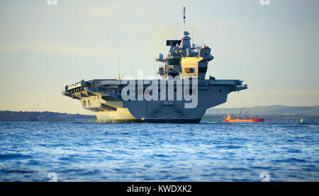 La Royal Navy porte-avions HMS Queen Elizabeth arrive au coucher du soleil à Portland, Dorset, sur la côte jurassique Banque D'Images