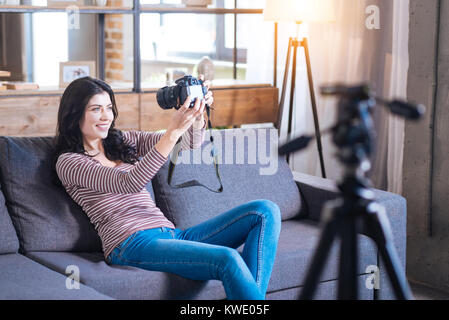 Cheerful woman assise sur le canapé Banque D'Images