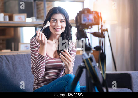 Belle femme séduisante à l'aide d'un pinceau à maquillage Banque D'Images