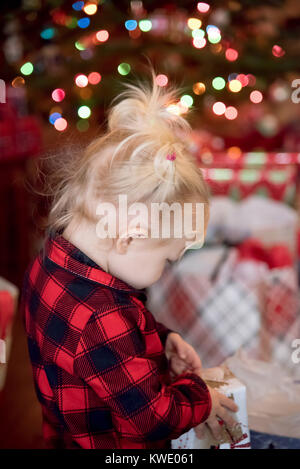 Heureux l'enfant dans la région de Buffalo vérifier pyjama cadeaux ouverture le matin de Noël Banque D'Images