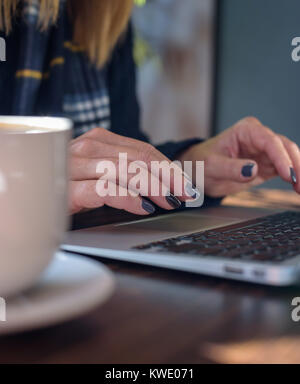 Femme libre de la saisie sur clavier d'ordinateur portable avec latte Banque D'Images