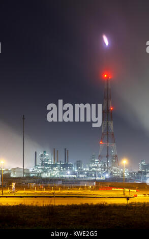 Une grande torchère dans une raffinerie de pétrole dans le port d'anvers la nuit. Banque D'Images