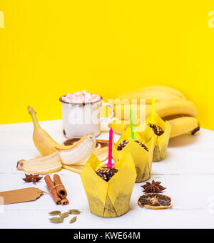 Muffins aux bananes avec bougies de fête sur un fond en bois blanc, vue du dessus Banque D'Images