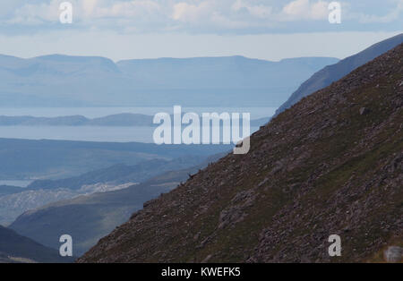 Vue depuis les montagnes de Torridon sur Raasay et l'île de Skye avec trois cerfs rouges sur le flanc Banque D'Images