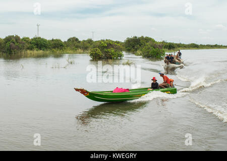 Un Cambodgien Asian couple assis sur un bateau, l'homme qui alimente le moteur powered long boat fine sur le Grand Lac Tonle Sap Kampong Phluk, plaine d'Asie Banque D'Images