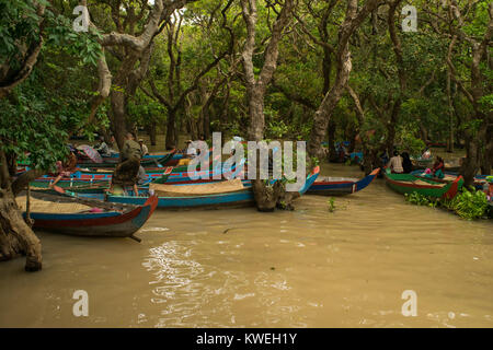 Les femmes cambodgiennes clients en attente et les touristes d'aller sur un bateau voyage de canoë parmi les arbres flottant noyé inondées forêt de Kampong Phluk,Siem Reap Banque D'Images