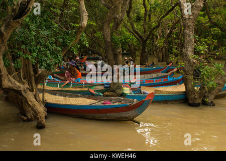 Les femmes cambodgiennes clients en attente et les touristes d'aller sur un bateau voyage de canoë parmi les arbres flottant noyé inondées forêt de Kampong Phluk,Siem Reap Banque D'Images