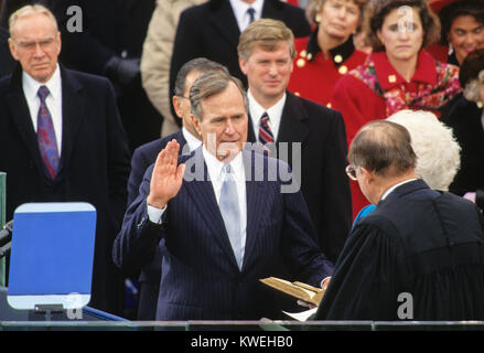 Le président des États-Unis George H. W. Bush est assermenté comme 41e président des États-Unis par le juge en chef William Rehnquist au Capitole le 20 janvier 1989. Le Président de la Chambre des Représentants américaine Jim Wright (démocrate du Texas) a l'air sur de la gauche et le Vice-président américain Dan Quayle ressemble à du centre. Credit : Arnie Sachs / CNP /MediaPunch Banque D'Images