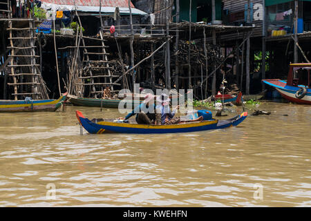 Un couple de femmes cambodgiennes asiatique assis sur un bateau, se déplaçant dans Kampong Phluk village flottant sur pilotis sur petit bleu et jaune en canot. Cambodge Banque D'Images