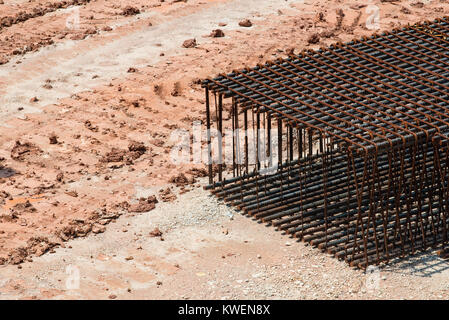 Couper les tiges et barres en acier assis sur le sol d'un chantier en attente d'être mélangé avec du béton dans les fondations des bâtiments Banque D'Images