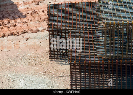 Couper les tiges et barres en acier assis sur le sol d'un chantier en attente d'être mélangé avec du béton dans les fondations des bâtiments Banque D'Images