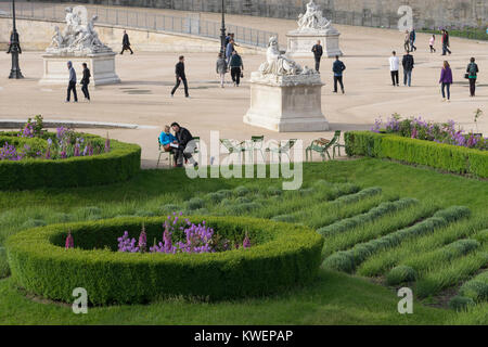 France, Paris, Young Couple dans Truileries avec jardin de fleurs et de verdure Banque D'Images