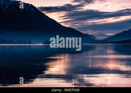 A la fin de novembre le coucher du soleil sur le Loch Leven et Beinn a' Bheithir Invercoe de prises, près de Glen Coe en Écosse. comme la brume flotte au-dessus de la surface de la Banque D'Images