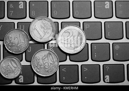 Pièces en euro sur le clavier de l'ordinateur portable - faire de l'argent en ligne Banque D'Images