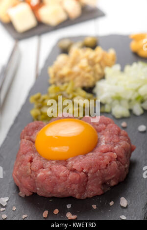 Tartare frais maison steak de boeuf avec oeuf sur la plaque en ardoise noire Banque D'Images