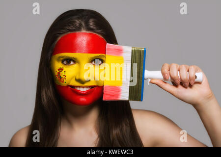 Le visage d'une femme dans les couleurs nationales de l'Espagne Banque D'Images