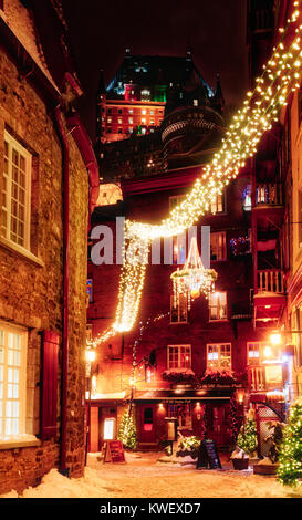 Décorations de Noël et de la neige fraîche à Québec's Petit Champlain dans la nuit - Rue Cul-de-sac avec le Château Frontenac au-dessus Banque D'Images